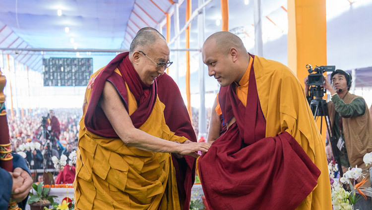 His Holiness the Dalai Lama exchanging greetings with Gyalwang Karmapa as he arrives on stage for the second day of the Kalachakra Empowerment, Seven Empowerments in the Pattern of Childhood, in Bodhgaya, Bihar, India on January 12, 2017. Photo/Tenzin Choejor/OHHDL Зураг: Дээрхийн гэгээнтэн Далай лам 2017 оны 1-р сарын 12-ны өдөр Энэтхэгийн Бихар мужийн Бодгаяа хотод болох Дүйнхорын ван буюу долоон рашааны вангийн хоёр дахь чуулганд оролцож буй Гялван Кармапатай мэндчилж байгаа нь. Гэрэл зургийг Тэнзин Чойжор/ДЛО