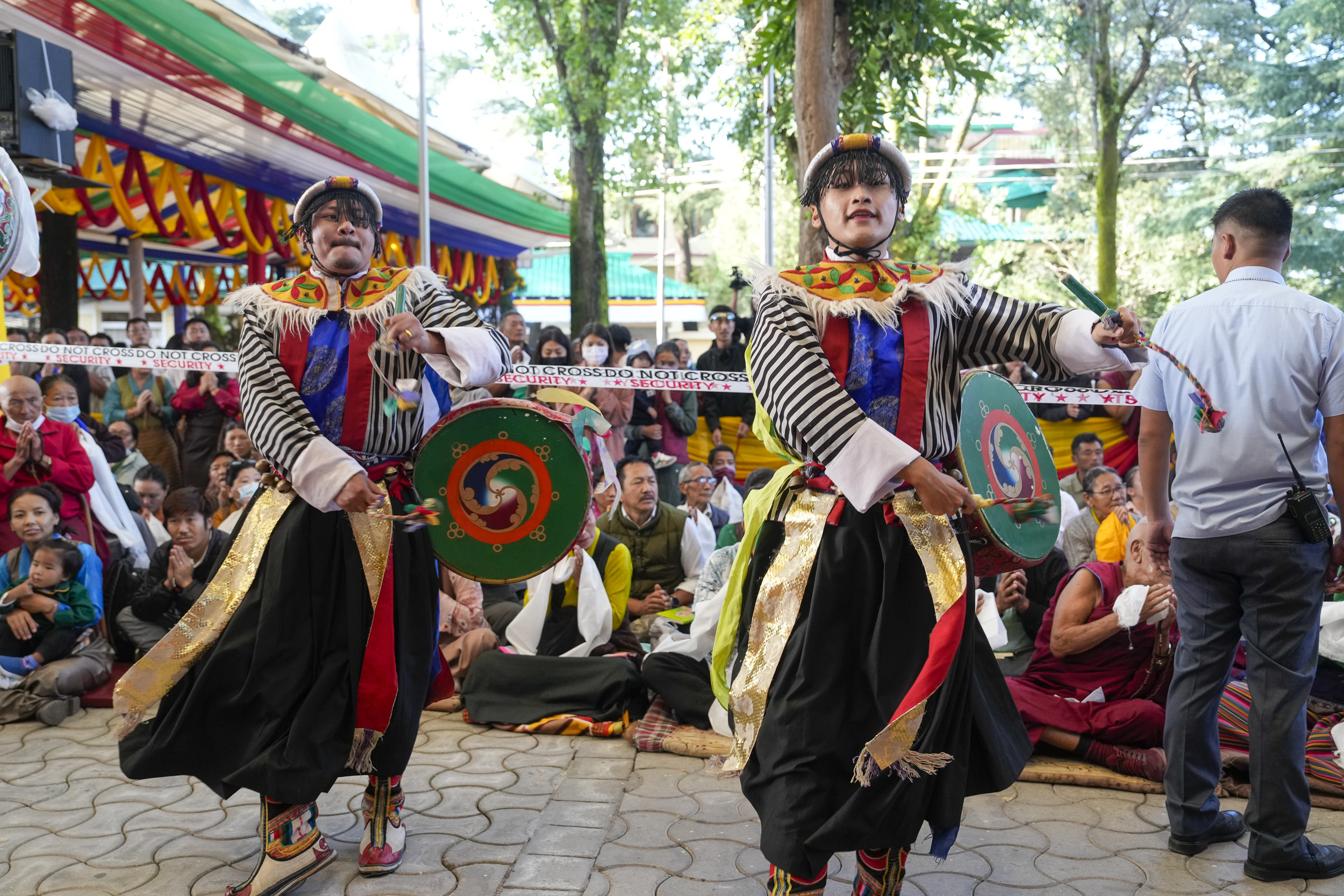 Зураг. Дээрхийн гэгээн Далай лам бат оршил өргөх ёслолд оролцохоор Намжал дацангийн Зүглэгхан дуганд морилон ирэх үед бүжигчид урлагийн тоглолтоо үзүүлж буй нь... Энэтхэг, Химачал Прадеш, Дарамсала дахь 2024 оны 9 дүгээр сарын 18. Гэрэл зургийг Дэнзин Чойжир.
