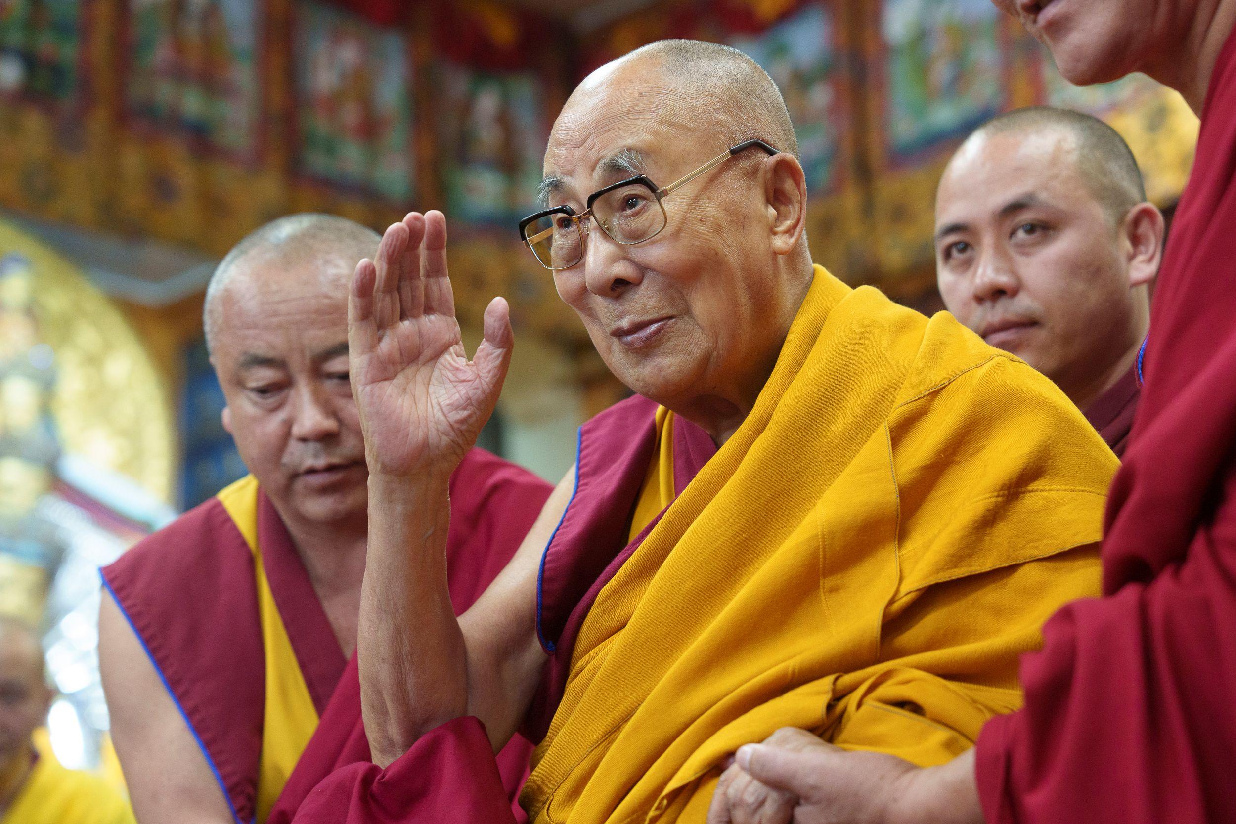 Зураг. Дээрхийн гэгээн Намжал дацангийн Зүглэгхан дуганд номын айлдвараа өндөрлөөд сүсэгтэн олонтой гар даллан мэндчилж буй нь... Энэтхэг,  Химачал Прадеш муж,  Дарамсала хот. 2024 оны 9 дүгээр сарын 30. Гэрэл зургийг Дэнзин Чойжир.