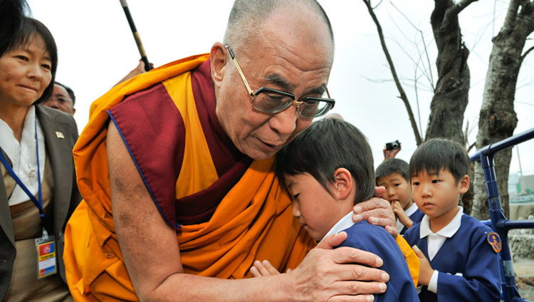 His Holiness the Dalai Lama comforting a young survivor during his visit to the Tsunami devastated region of Sendai, Japan on November 5, 2011. (Photo by Tenzin Choejor/OHHDL)